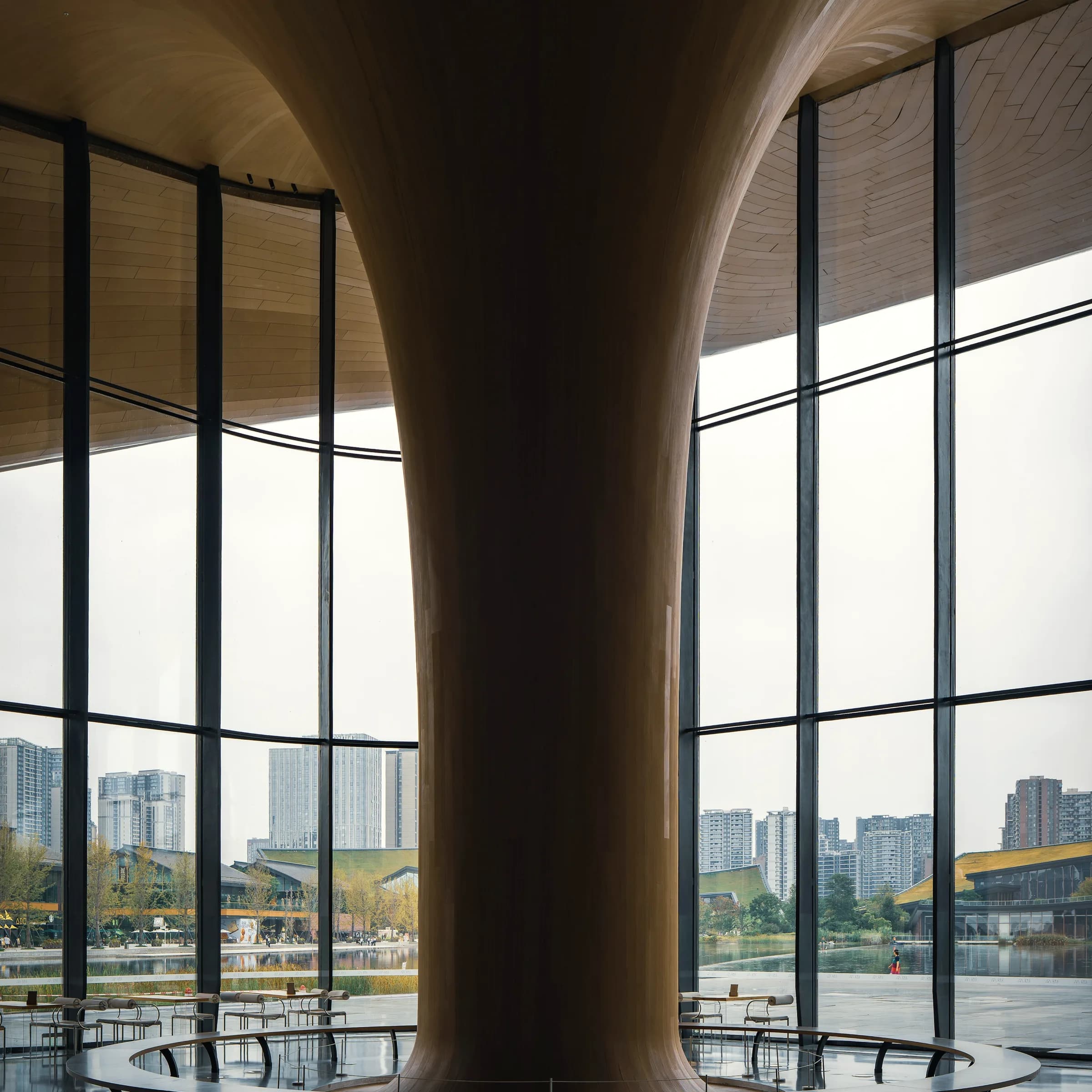 Tapered columns opening into the soffit above a glazed ground floor.