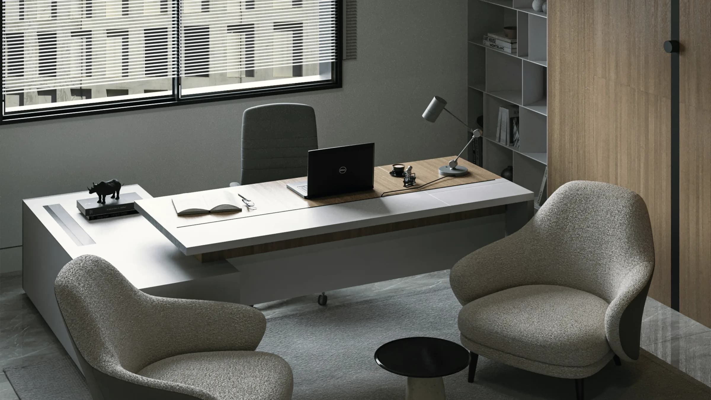 A single desk against a plain wall in a quiet corner of a workplace floor.