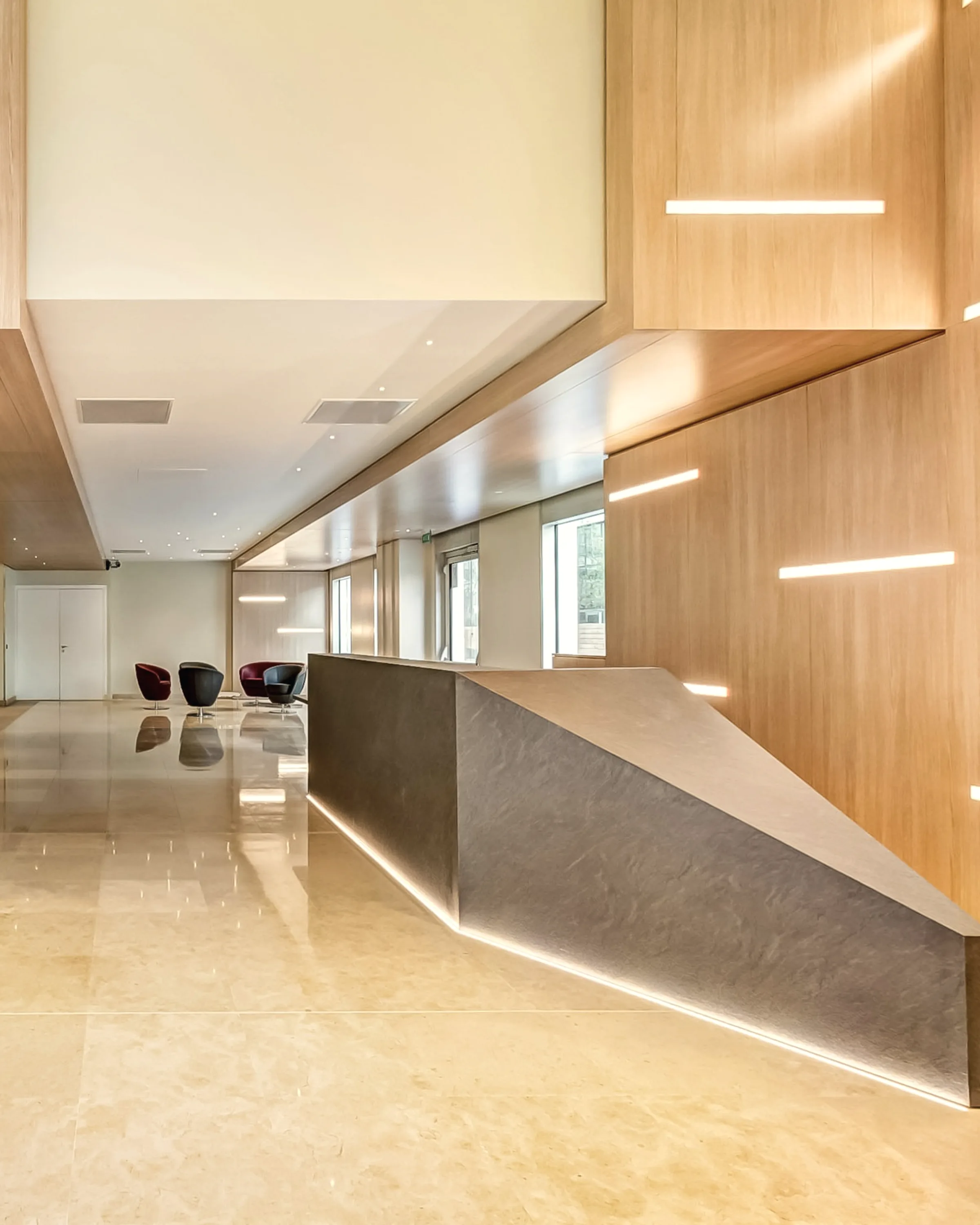 An open workplace floor lit from a full-height glazed wall.