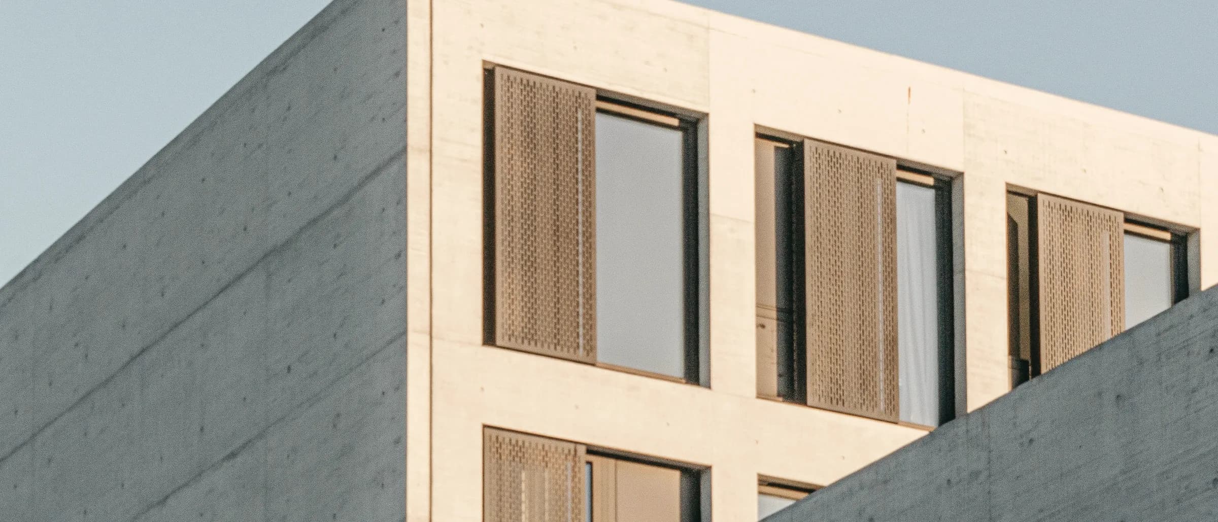 A workplace building in pale concrete and glass, its structure expressed on the elevation.