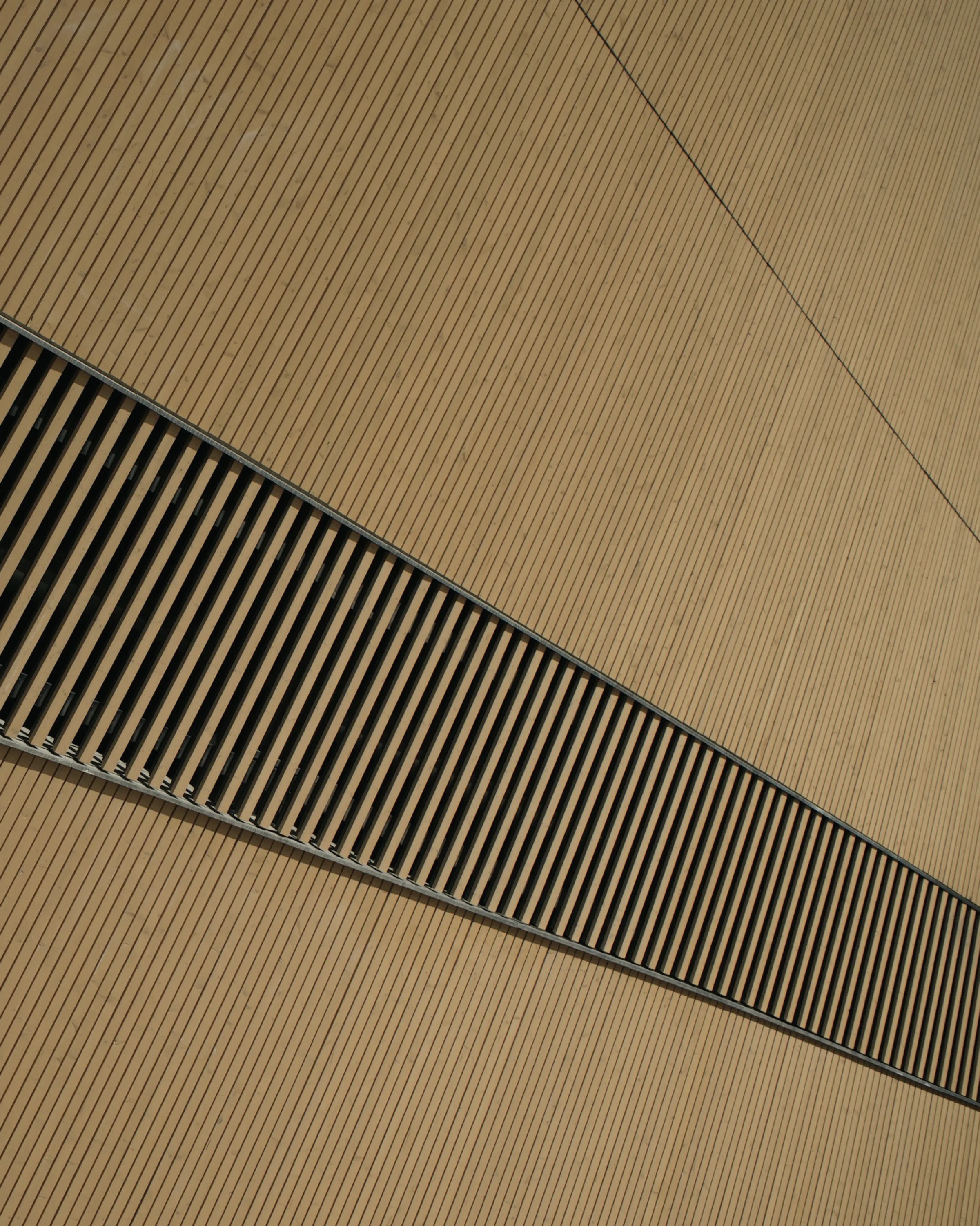 A detail of a public building facade, its cladding lapped like boarding.