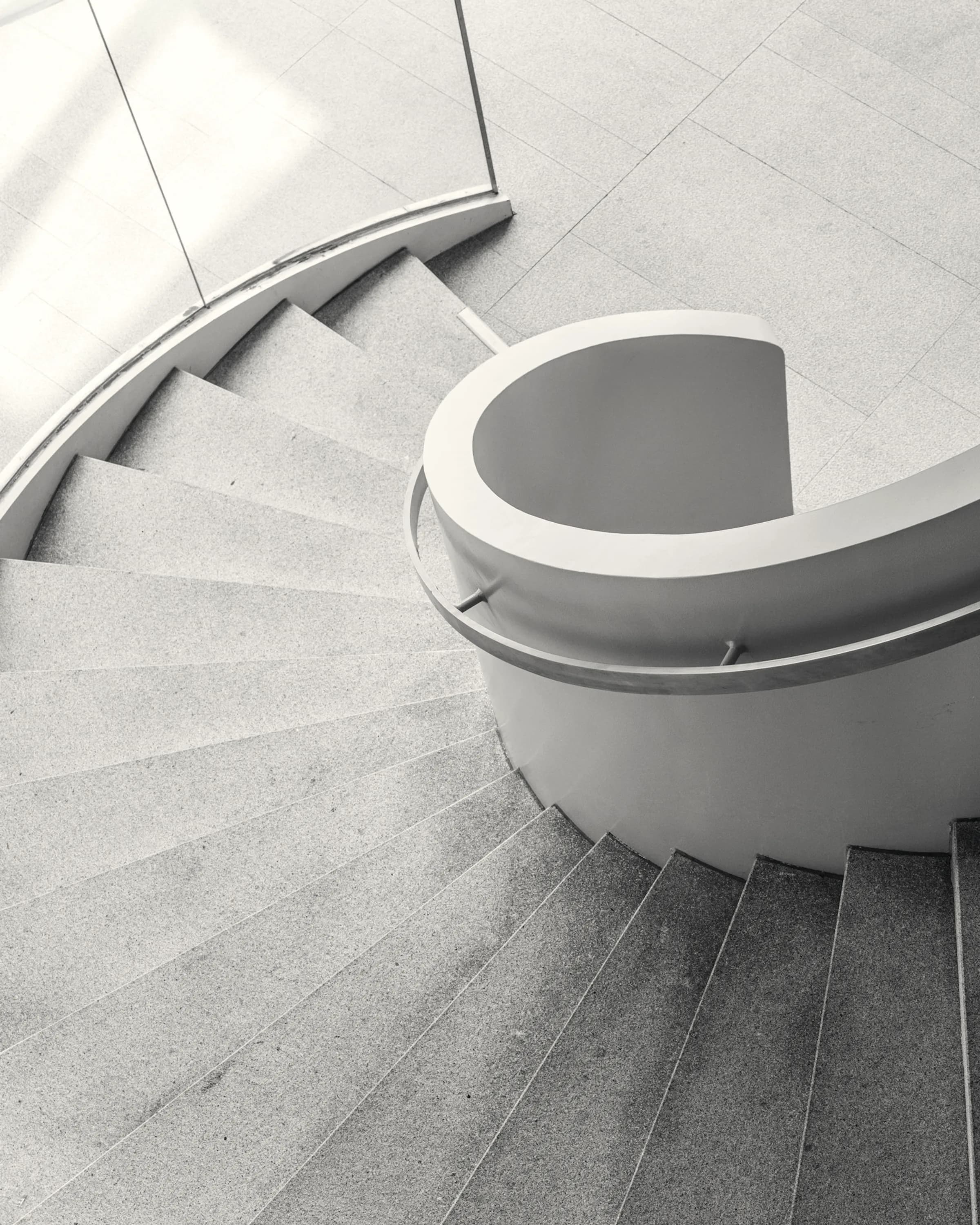 A spiral stair seen from above, reduced to a single turning line.