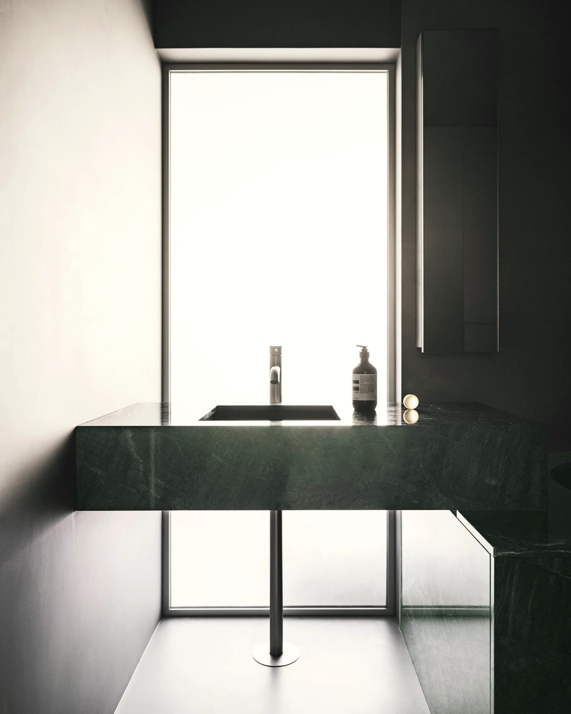 A dark stone surface meeting a lit recess in an interior.
