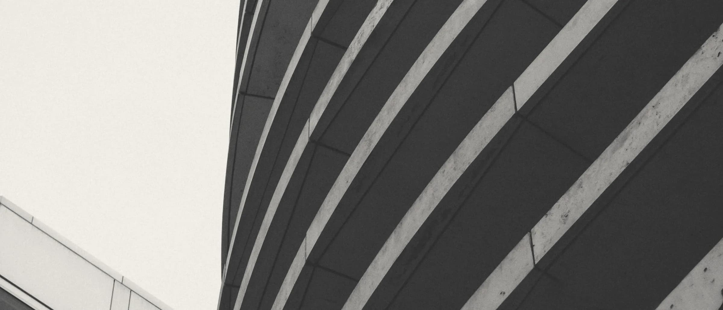A tall office building seen against a flat sky, its facade reduced to vertical fins.
