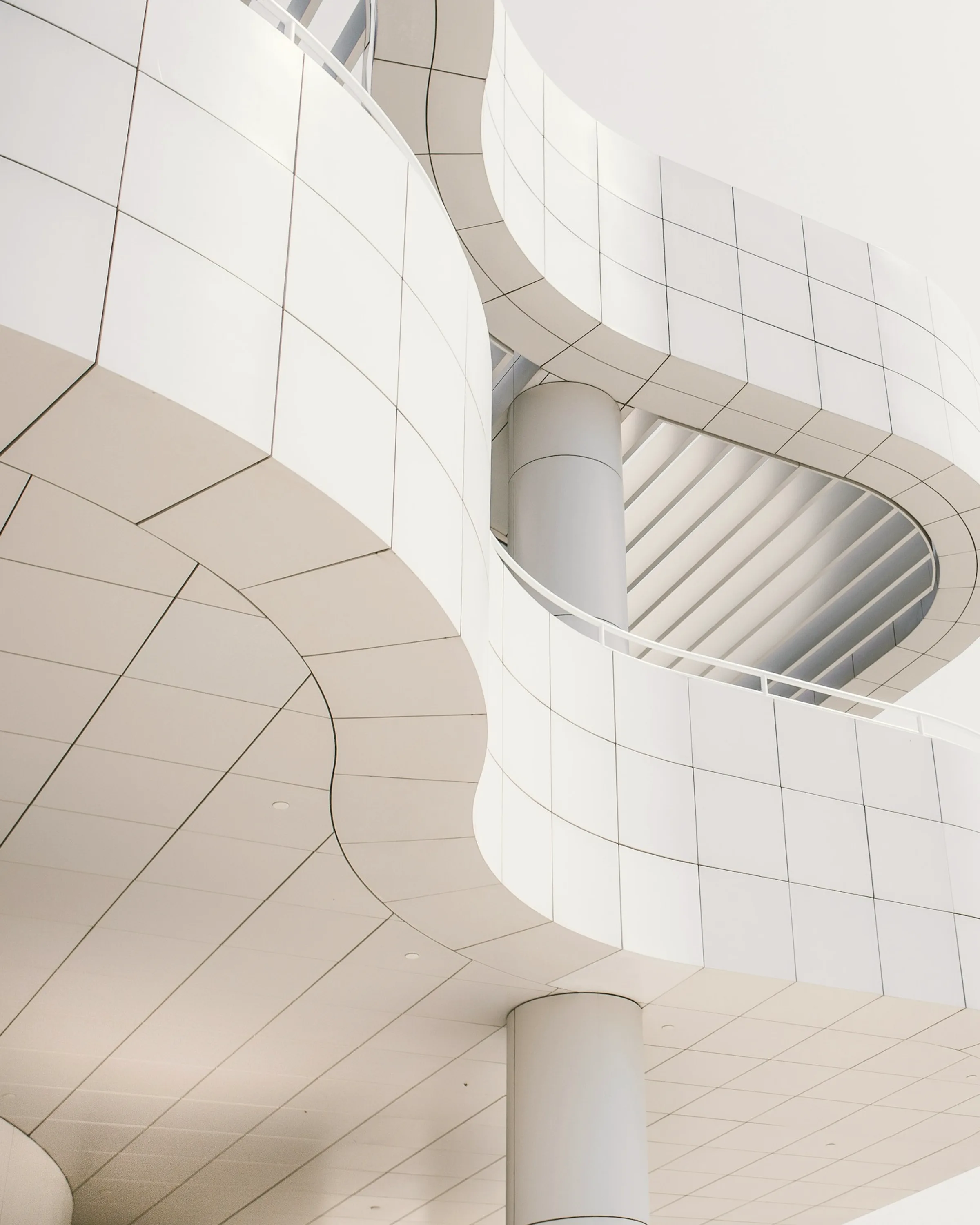 A concrete structure seen from directly below, the frame converging overhead.