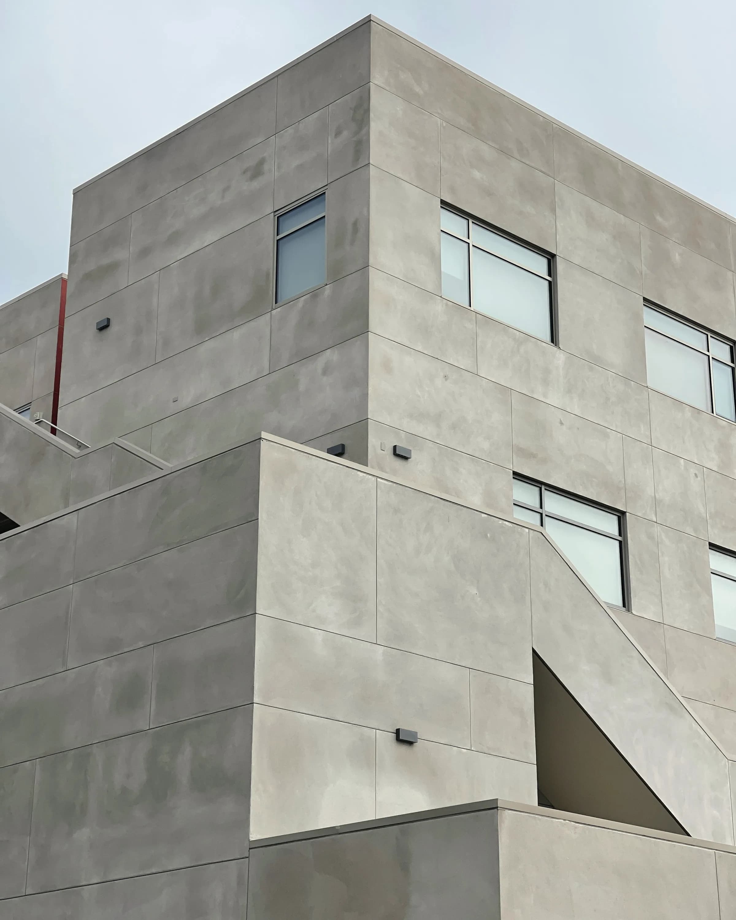 A concrete elevation with deep window reveals, the shadow cast square across the face.
