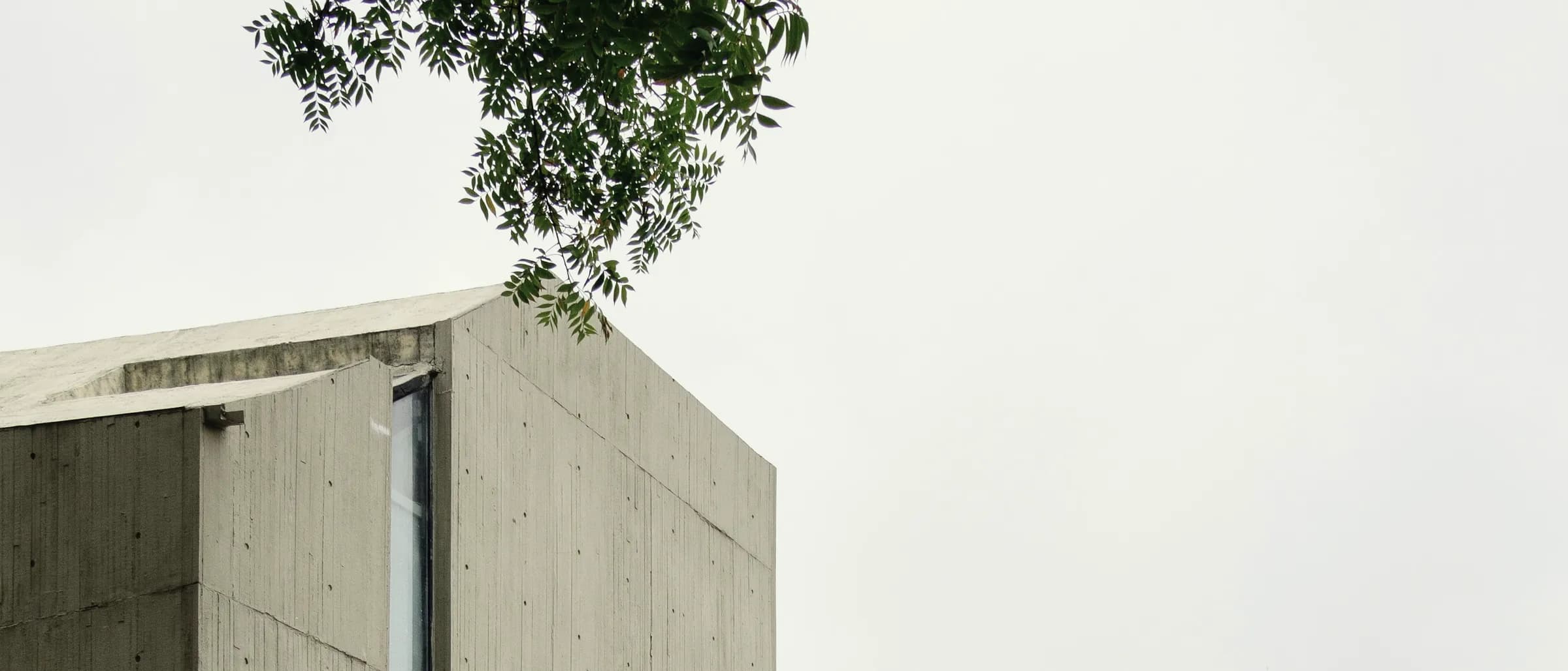 A concrete building stepping up its site, an external stair cut into the mass.