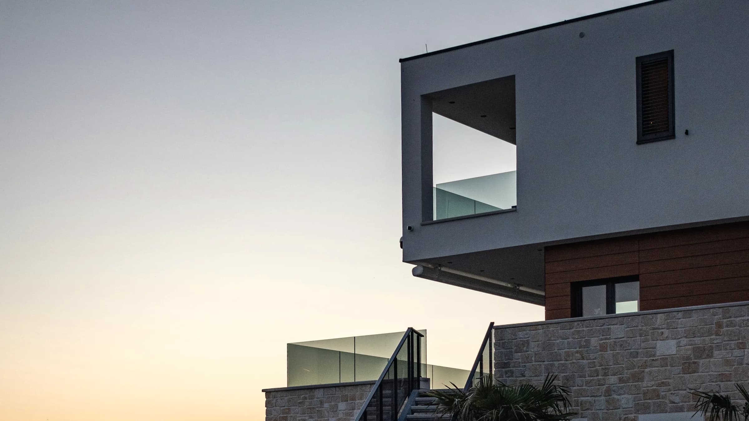 A concrete building standing directly on the water, its horizontal line held against the surface.